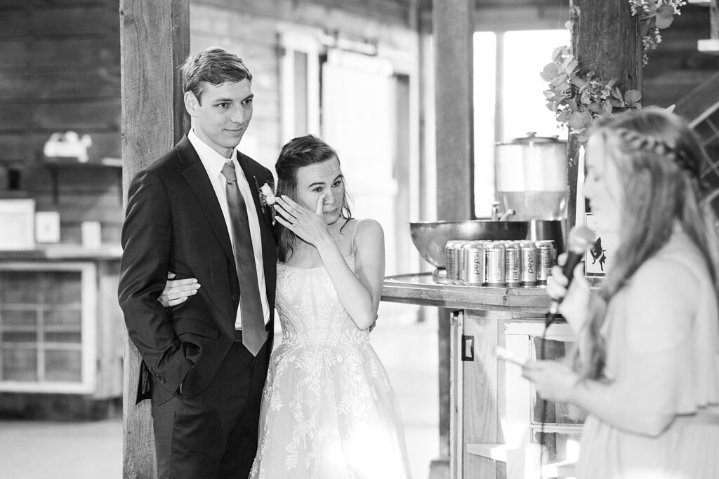 Bride wiping tear during toast | Amazing Graze Barn Wedding | Amazing Graze Barn Wedding Photographer