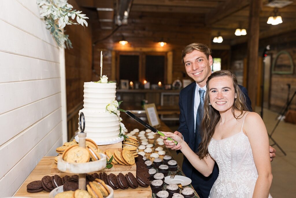 Bride and groom cutting wedding cake | Amazing Graze Barn Wedding | Amazing Graze Barn Wedding Photographer
