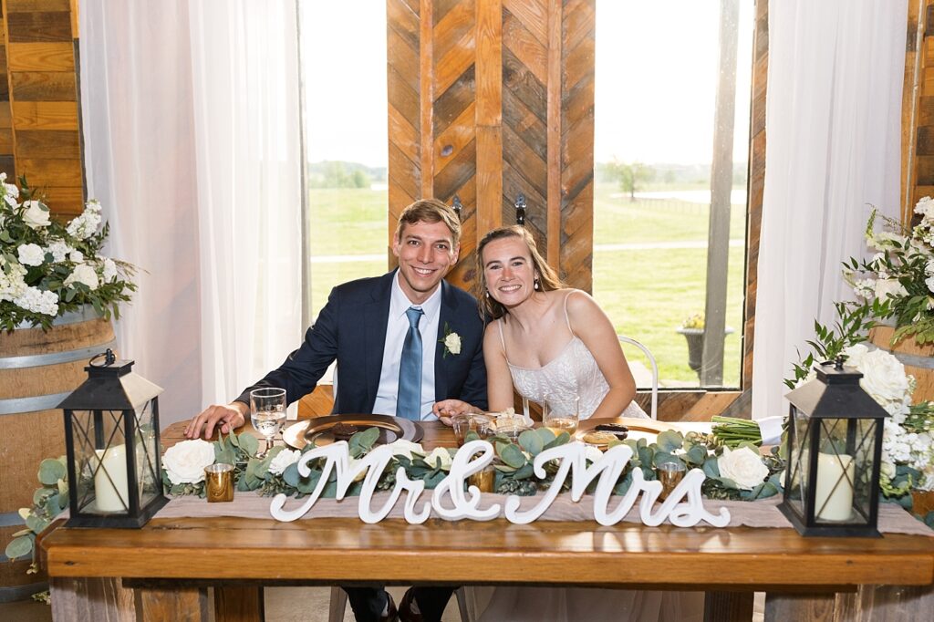 Bride and groom sitting at main table | Amazing Graze Barn Wedding | Amazing Graze Barn Wedding Photographer