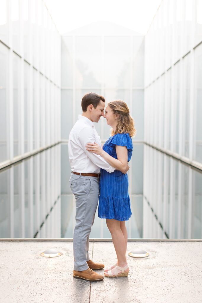 Couple embracing each other in front of reflecting pool | Spring engagement photos | Raleigh NC Engagement Photographer | Raleigh NC Museum of Art Engagement Session