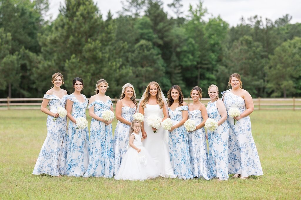 Bride posing with bridesmaids holding peony bouquets | classic blue and white bridesmaid dresses | The Evermore Wedding | The Evermore Wedding Photographer | Raleigh NC Wedding Photographer