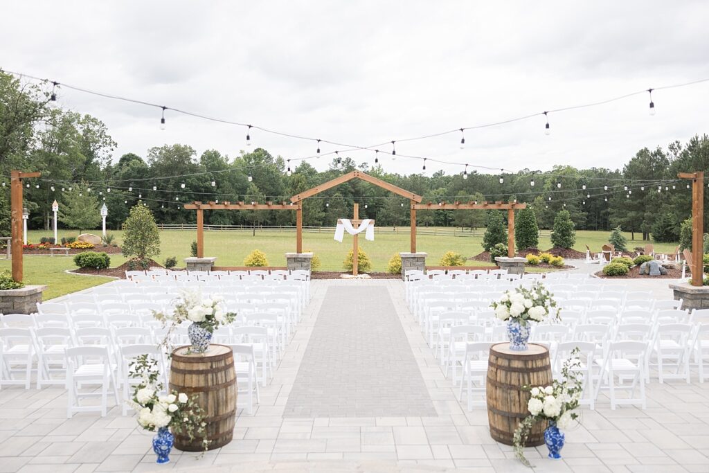 Outdoor wedding ceremony location with ginger jars holding white flowers | The Evermore Wedding | The Evermore Wedding Photographer | Raleigh NC Wedding Photographer