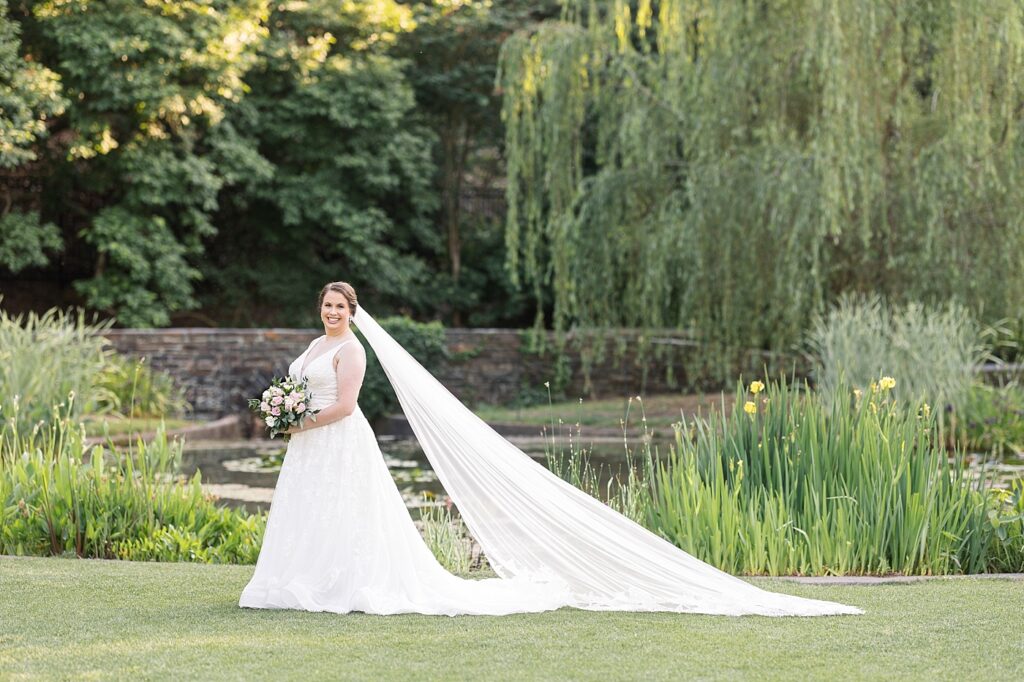 Bride posing near pond in garden with bouquet and veil | Bridal Portraits at Duke Gardens | Raleigh NC Wedding Photographer | Bridal Portrait Photographer