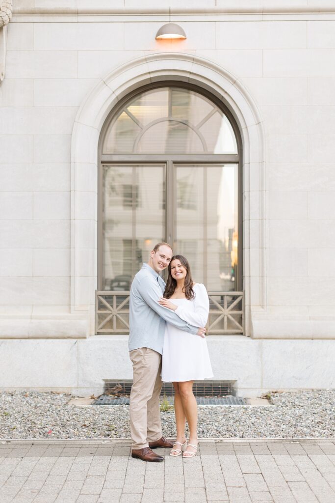 Couple embracing and standing in front of tall window | Raleigh NC Engagement Photographer | Sarah Hinckley Wedding Photographer