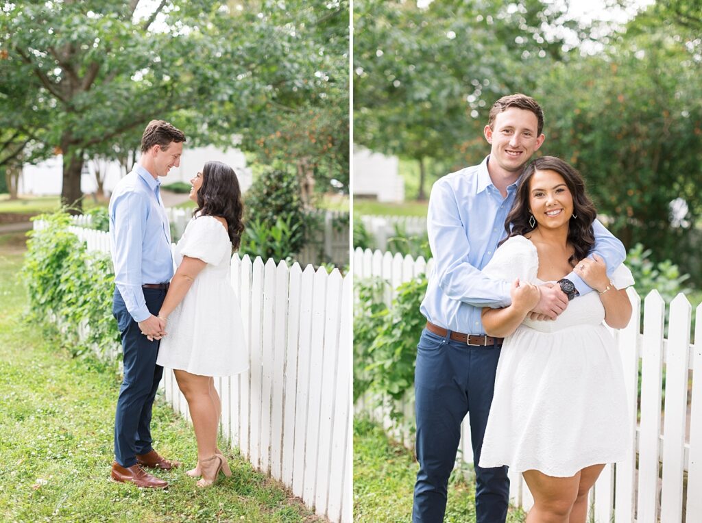 Couple holding hands and embracing by white fence outside | Raleigh NC Engagement Photographer | Historic Oak View Engagement Session