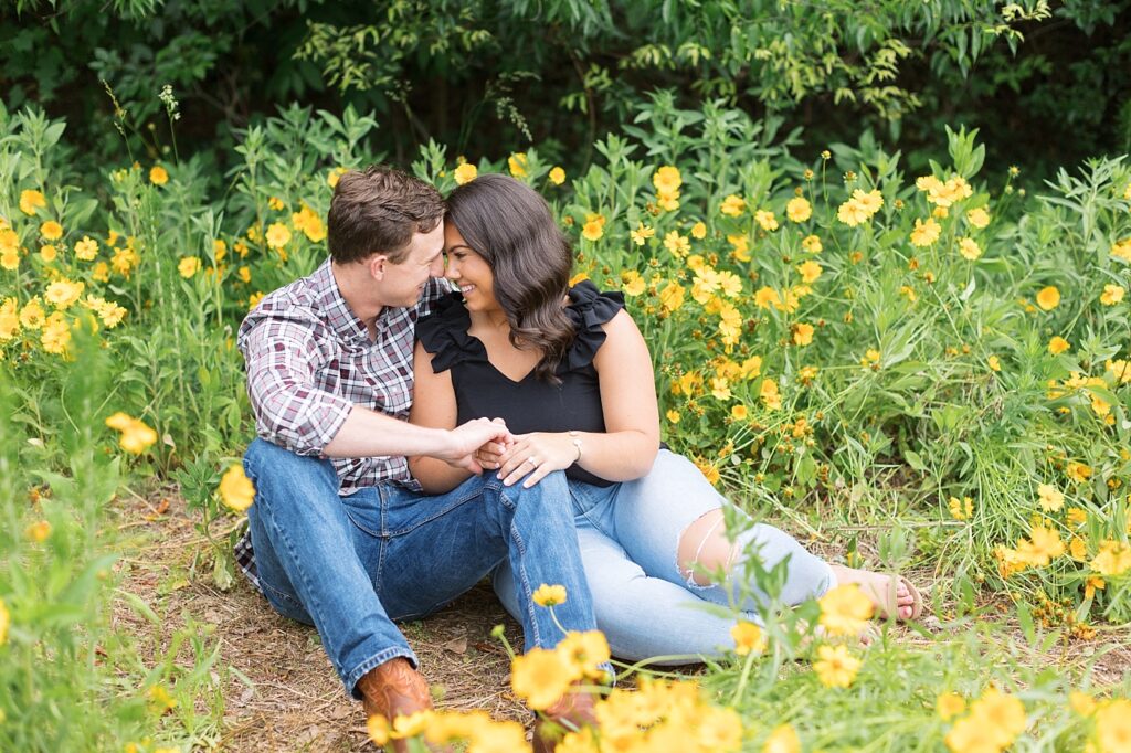 Couple staring at each other in field of yellow flowers | Raleigh NC Engagement Photographer | Historic Oak View Engagement Session