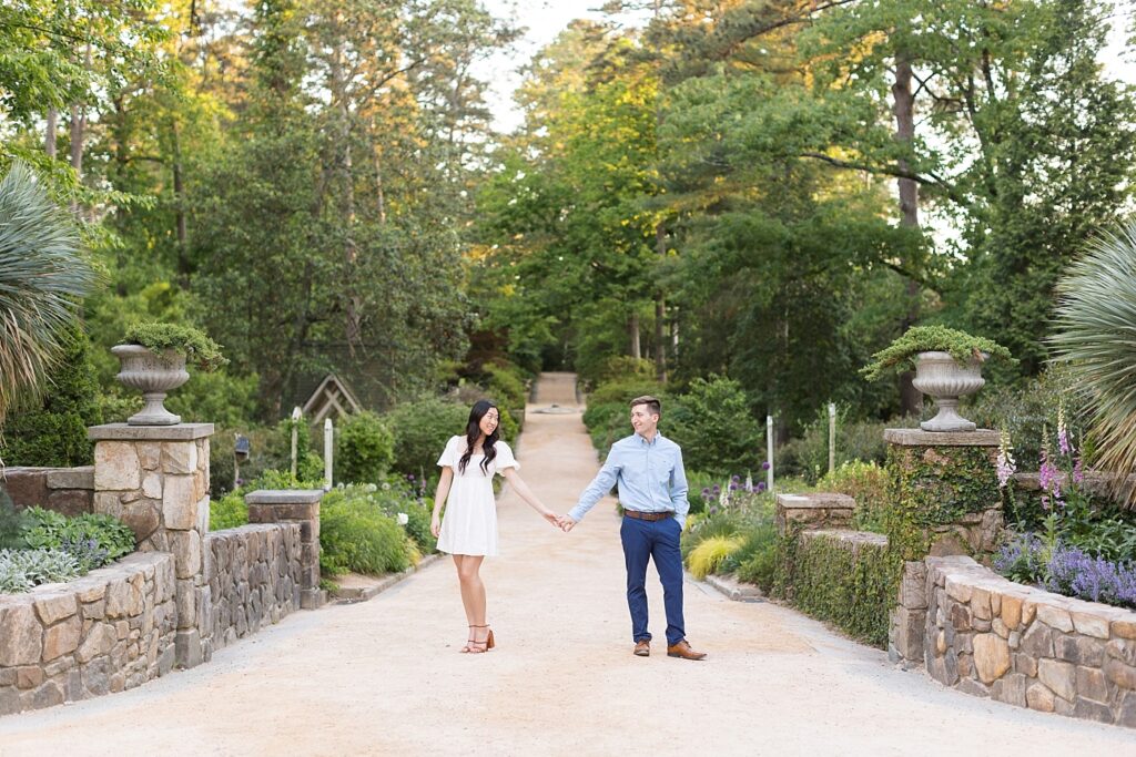 Couple holding hands in middle of garden | Duke Gardens engagement photos | Raleigh NC wedding photographer 
