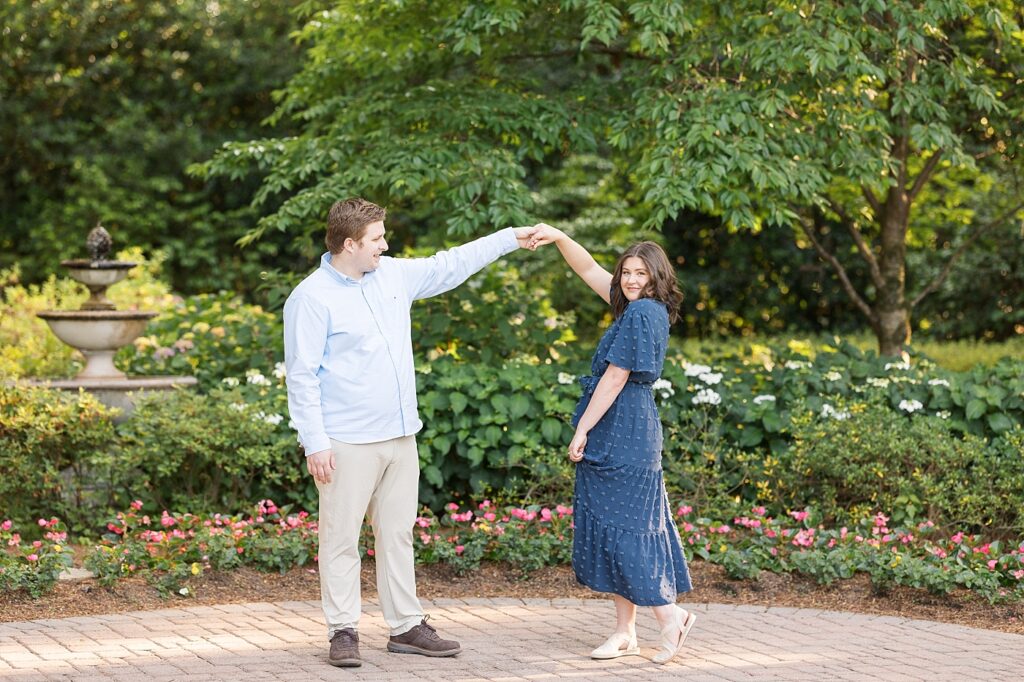 Couple dancing in garden near fountain | WRAL Gardens engagement photos | Raleigh NC wedding photographer 