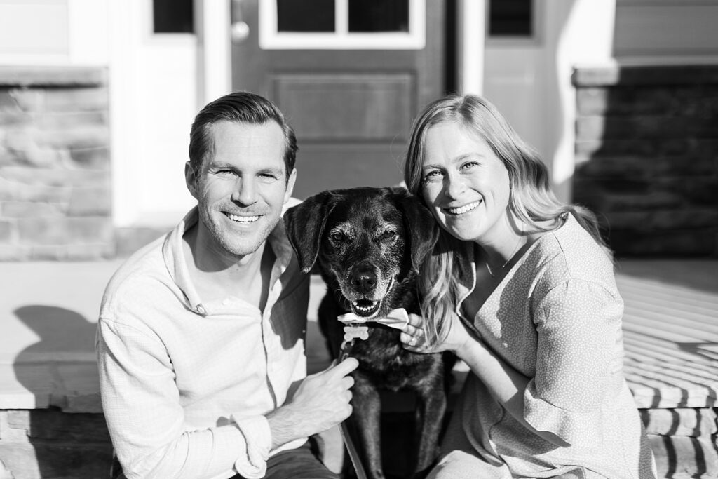 Couple smiling with their dog in between them | Yates Mill engagement photos | Raleigh NC wedding photographer 