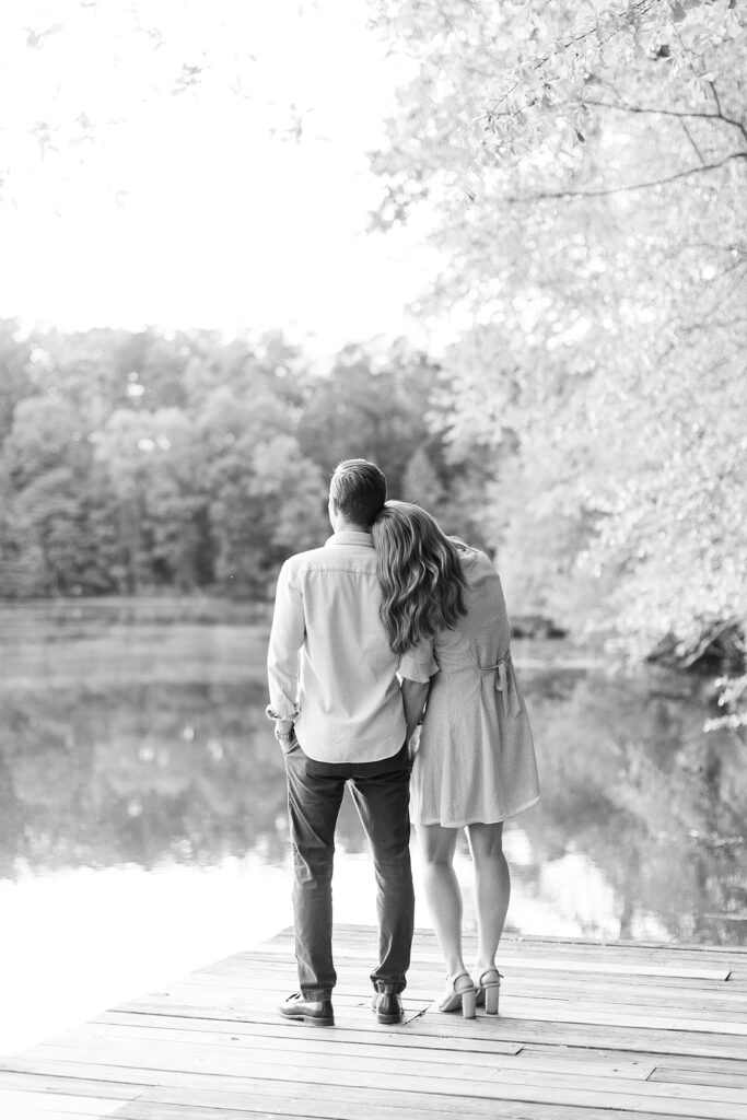 Couple embracing and staring out at the lake | Yates Mill engagement photos | Raleigh NC wedding photographer 