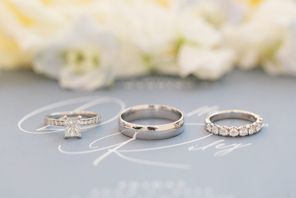 Wedding rings displayed on top of wedding invitation | Blue and white Wedding | Carolina Groves Wedding | Carolina Groves Wedding Photographer | Raleigh NC Wedding Photographer