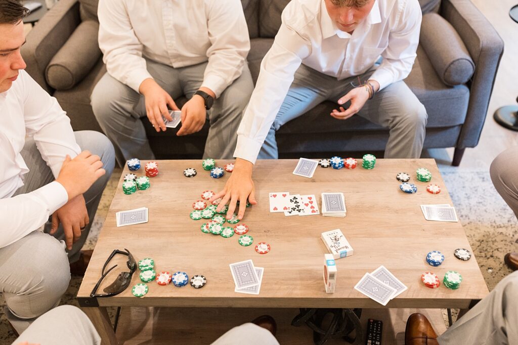 Groomsmen playing card game on rustic table | Blue and white Wedding | Carolina Groves Wedding | Carolina Groves Wedding Photographer | Raleigh NC Wedding Photographer