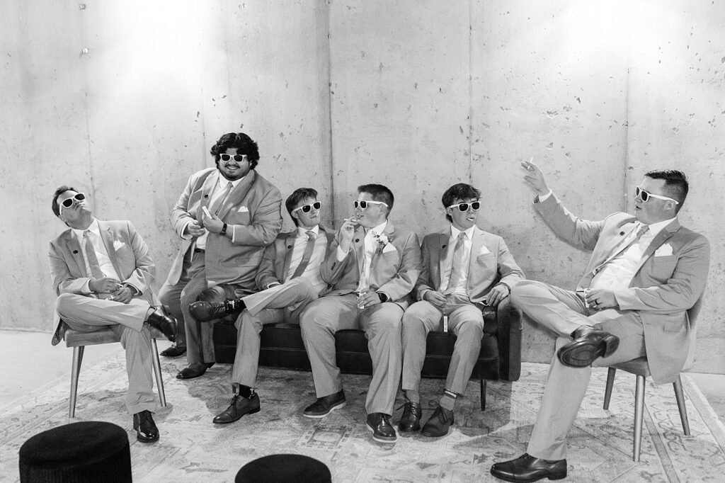 Groomsmen lounging in their suits wearing sunglasses | Blue and white Wedding | Carolina Groves Wedding | Carolina Groves Wedding Photographer | Raleigh NC Wedding Photographer