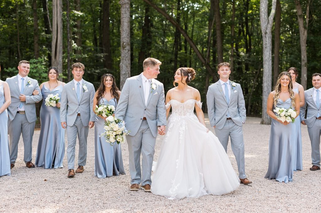 Bride and groom holding hands in front of wedding party | Blue and white Wedding | Carolina Groves Wedding | Carolina Groves Wedding Photographer | Raleigh NC Wedding Photographer