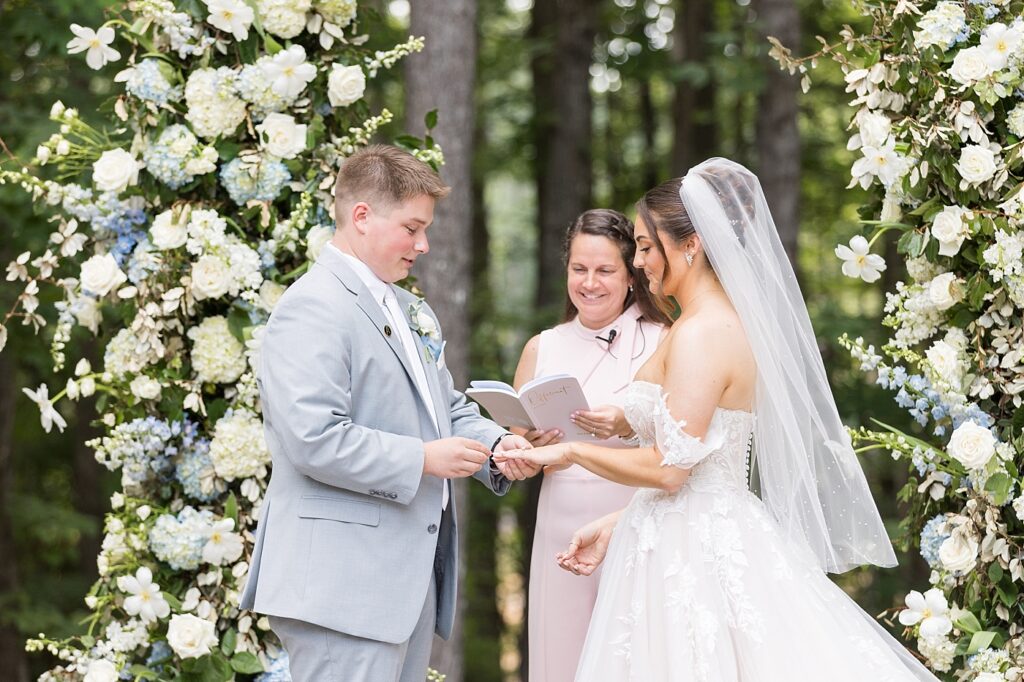 Groom placing wedding band on bride's finger | Blue and white Wedding | Carolina Groves Wedding | Carolina Groves Wedding Photographer | Raleigh NC Wedding Photographer