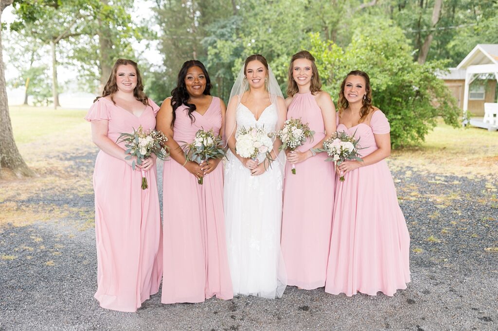 Bride and bridal party smiling while holding bouquets | Rustic wedding | Harvest House Wedding | Harvest House Photographer | Raleigh NC Wedding Photographer