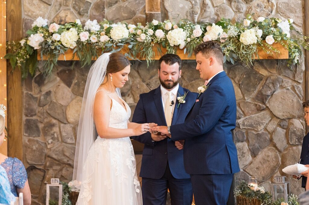 Bride putting on groom's ring during wedding ceremony | Rustic wedding | Harvest House Wedding | Harvest House Photographer | Raleigh NC Wedding Photographer