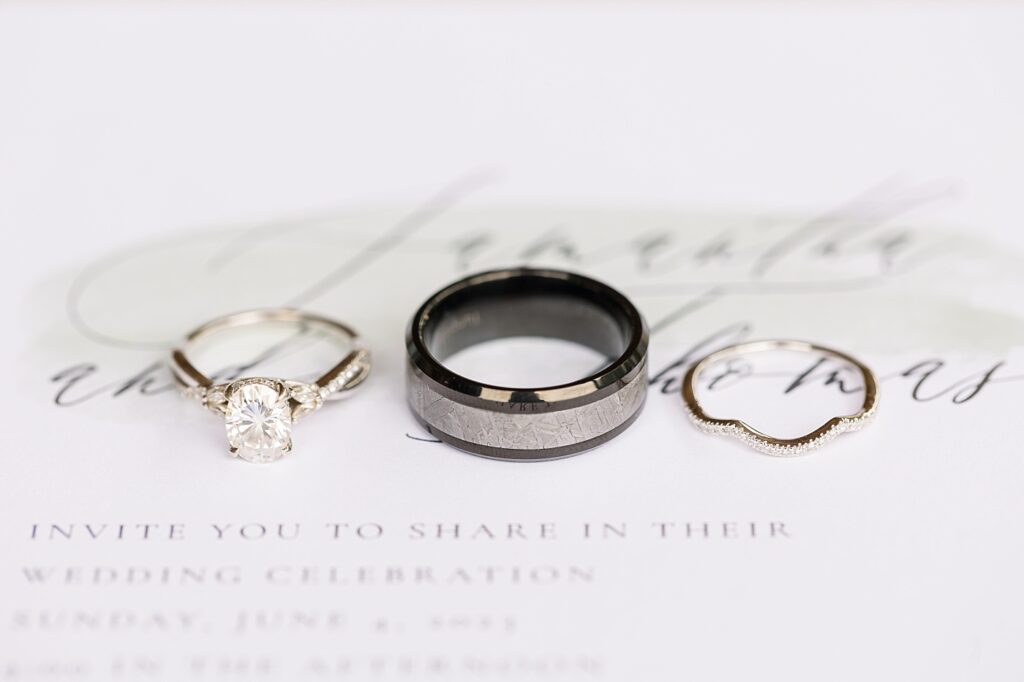 Wedding rings displayed on top of wedding invitation | Rustic Wedding | Twin Oaks Barn Wedding | Twin Oaks Barn Wedding Photographer | Raleigh NC Wedding Photographer