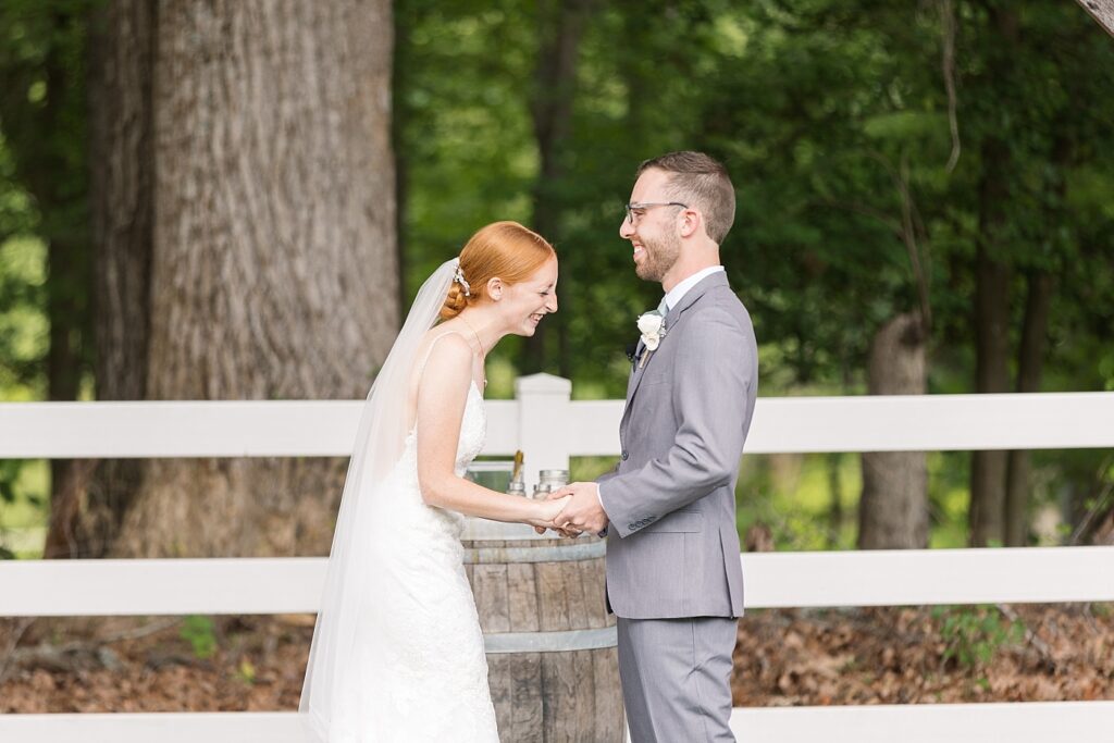 Bride and groom holding hands and smiling during wedding ceremony | Rustic Wedding | Twin Oaks Barn Wedding | Twin Oaks Barn Wedding Photographer | Raleigh NC Wedding Photographer