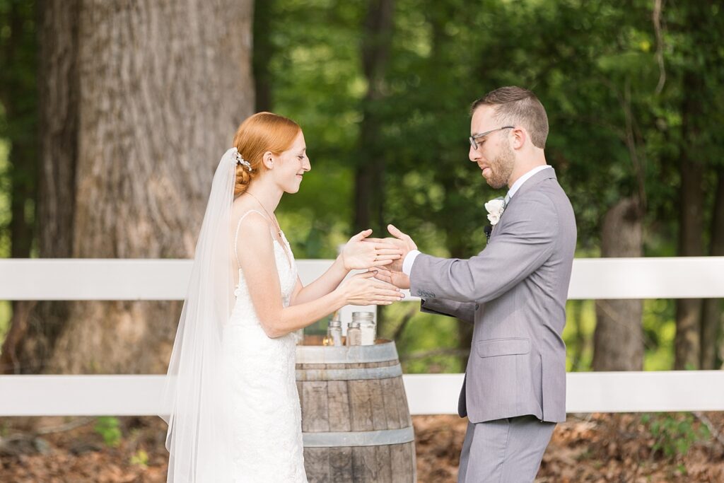 Bride and groom doing secret handshake during wedding ceremony | Rustic Wedding | Twin Oaks Barn Wedding | Twin Oaks Barn Wedding Photographer | Raleigh NC Wedding Photographer