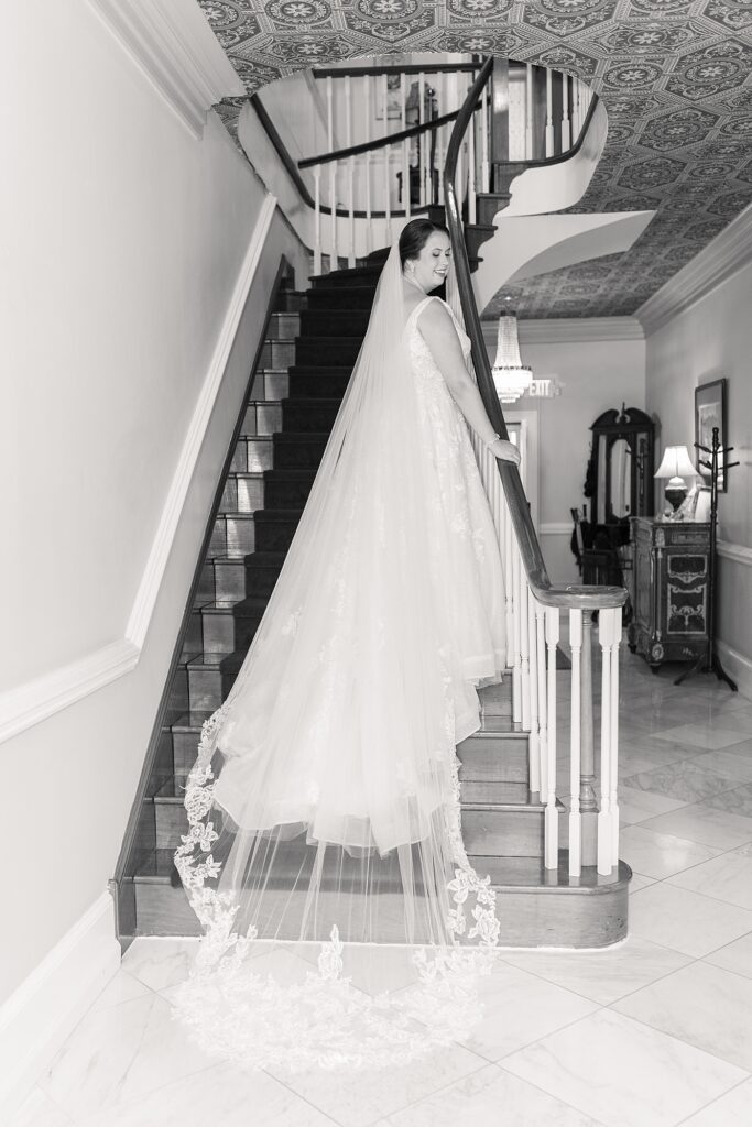 Bride standing on stairs wearing flowy vail | Summer Wedding | The Matthews House Wedding | The Matthews House Wedding Photographer | Raleigh NC Wedding Photographer