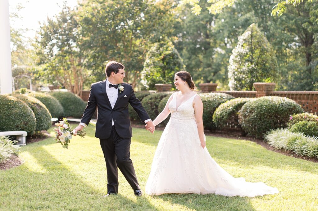 Bride and groom holding hands in garden | Summer Wedding | The Matthews House Wedding | The Matthews House Wedding Photographer | Raleigh NC Wedding Photographer