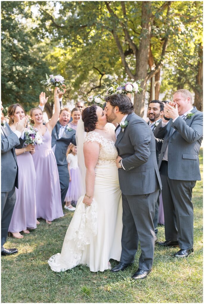 Wedding party cheering bride and groom kissing | Caffe Luna Wedding | Caffe Luna Wedding Photographer | Raleigh NC Wedding Photographer
