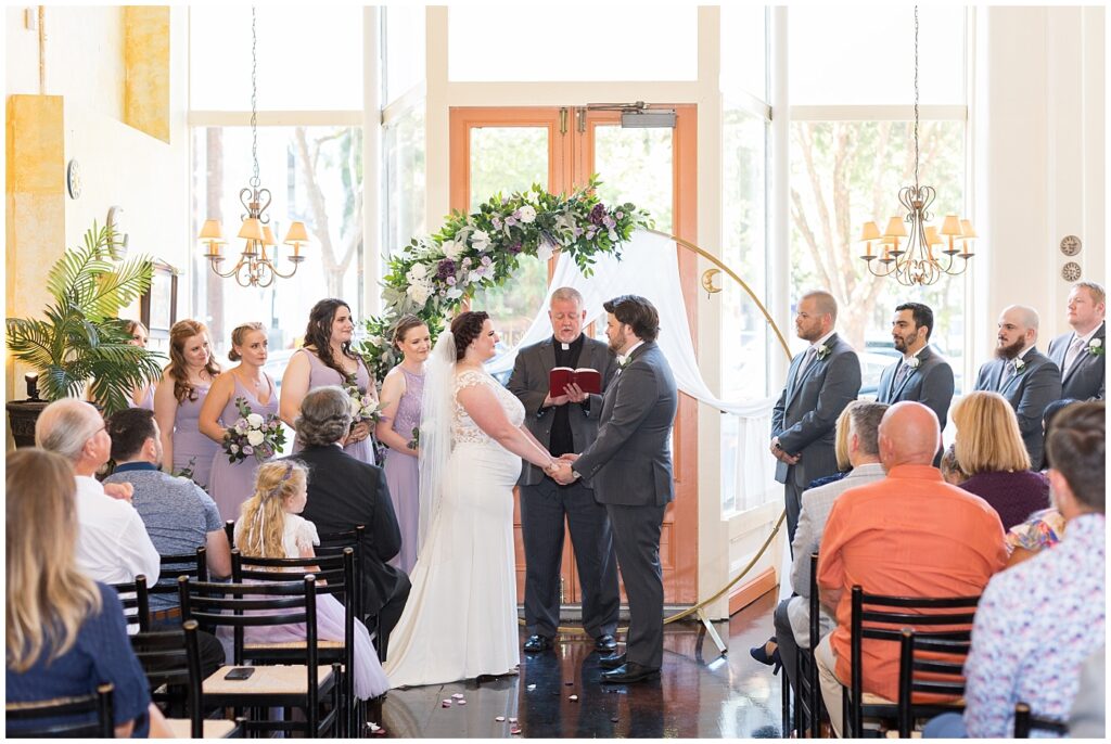 Bride and groom holding hands during wedding ceremony | Caffe Luna Wedding | Caffe Luna Wedding Photographer | Raleigh NC Wedding Photographer