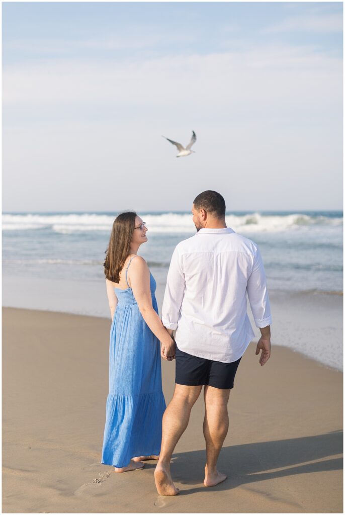 Outer banks engagement photos walking on the beach holding hands | NC Engagement Photographer