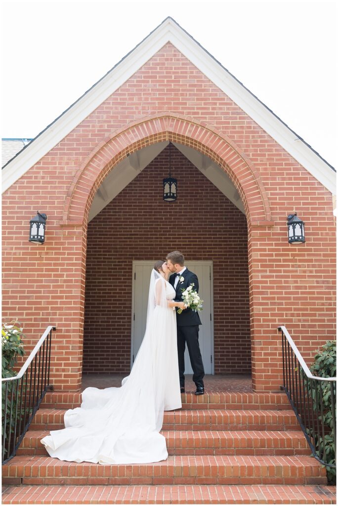 Bride and groom kissing at top of stairs | Summer Wedding | Angus Barn Wedding | Angus Barn Wedding Photographer | Raleigh NC Wedding Photographer