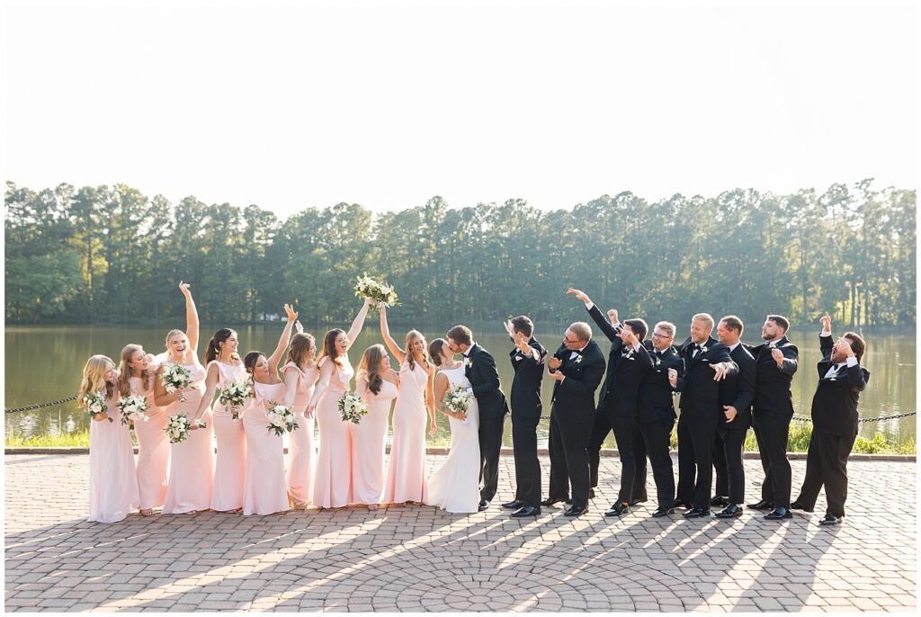 Wedding party cheering bride and groom by lake | Summer Wedding | Angus Barn Wedding | Angus Barn Wedding Photographer | Raleigh NC Wedding Photographer