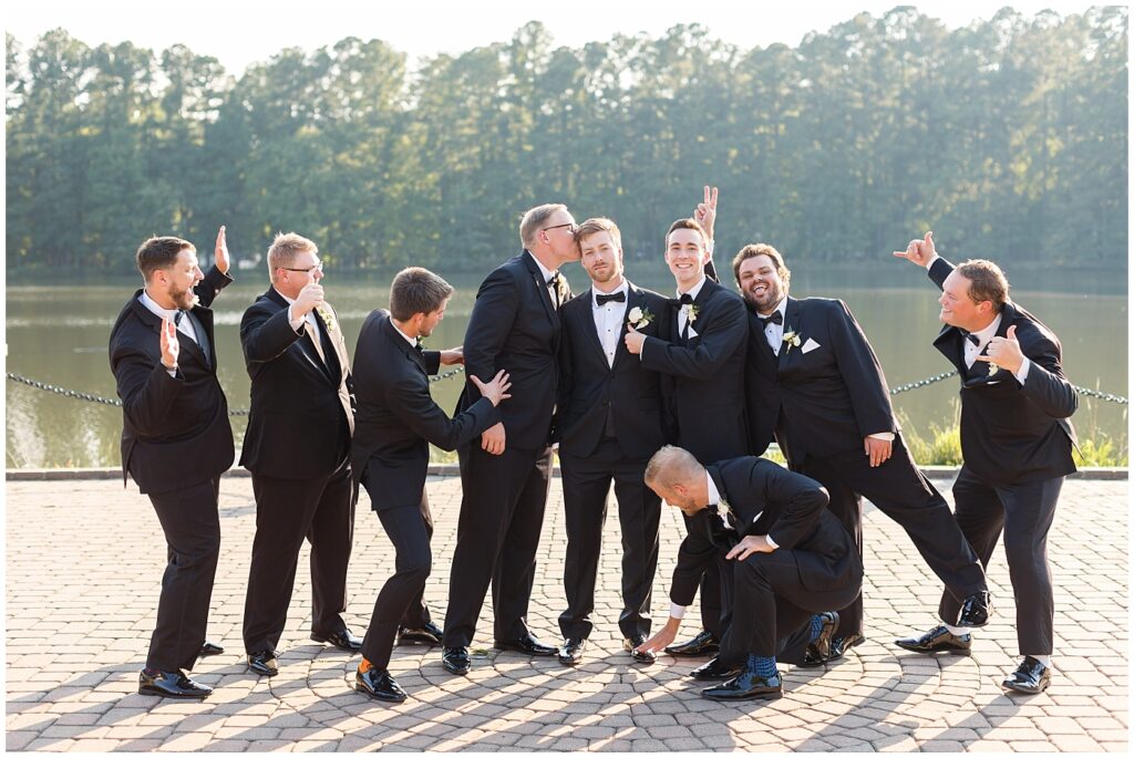 Groom and groomsmen standing by lake | Summer Wedding | Angus Barn Wedding | Angus Barn Wedding Photographer | Raleigh NC Wedding Photographer