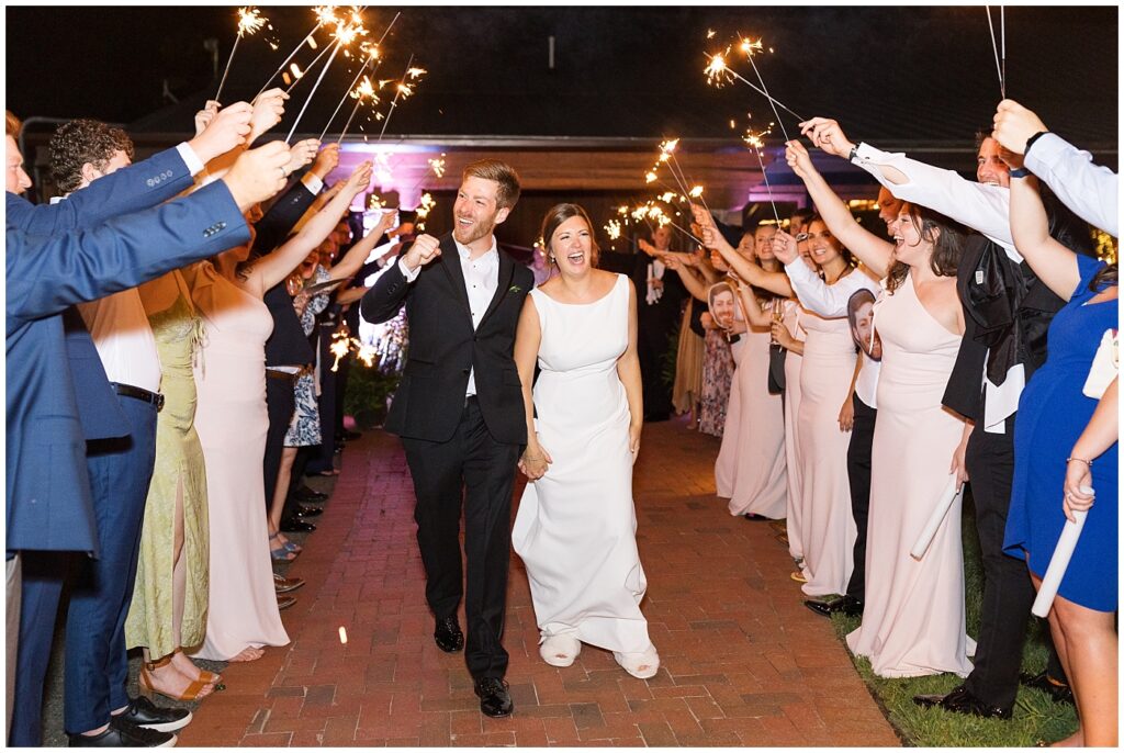Bride and groom holding hands during sparkler exit | Summer Wedding | Angus Barn Wedding | Angus Barn Wedding Photographer | Raleigh NC Wedding Photographer