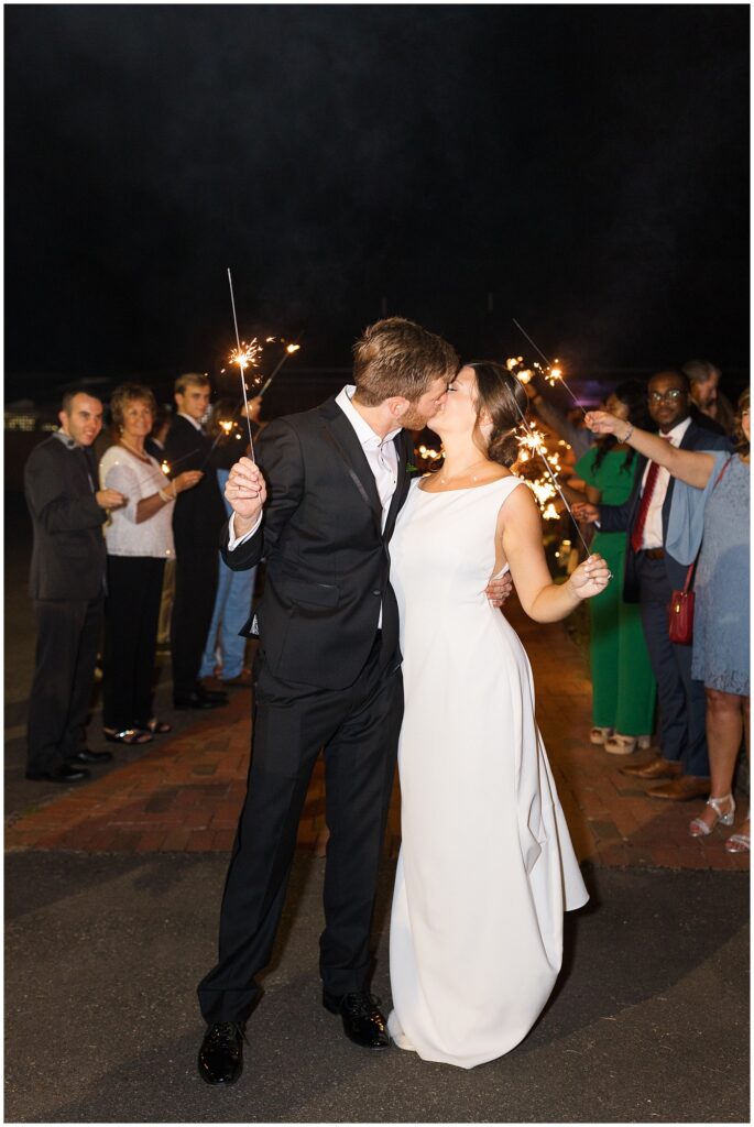 Bride and groom kissing during sparkler exit | Summer Wedding | Angus Barn Wedding | Angus Barn Wedding Photographer | Raleigh NC Wedding Photographer