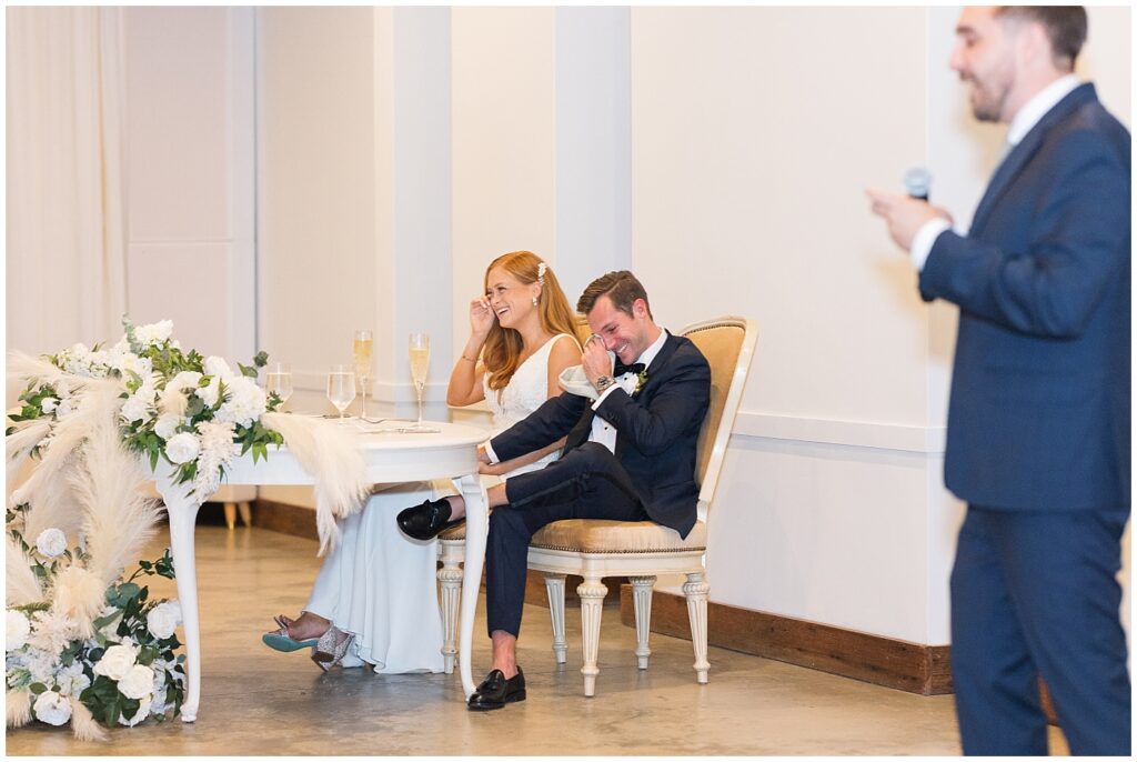 Groomsman giving toast during wedding reception and bride and groom laughing | The Meadows Wedding | The Meadows Wedding Photographer | Raleigh NC Wedding Photographer