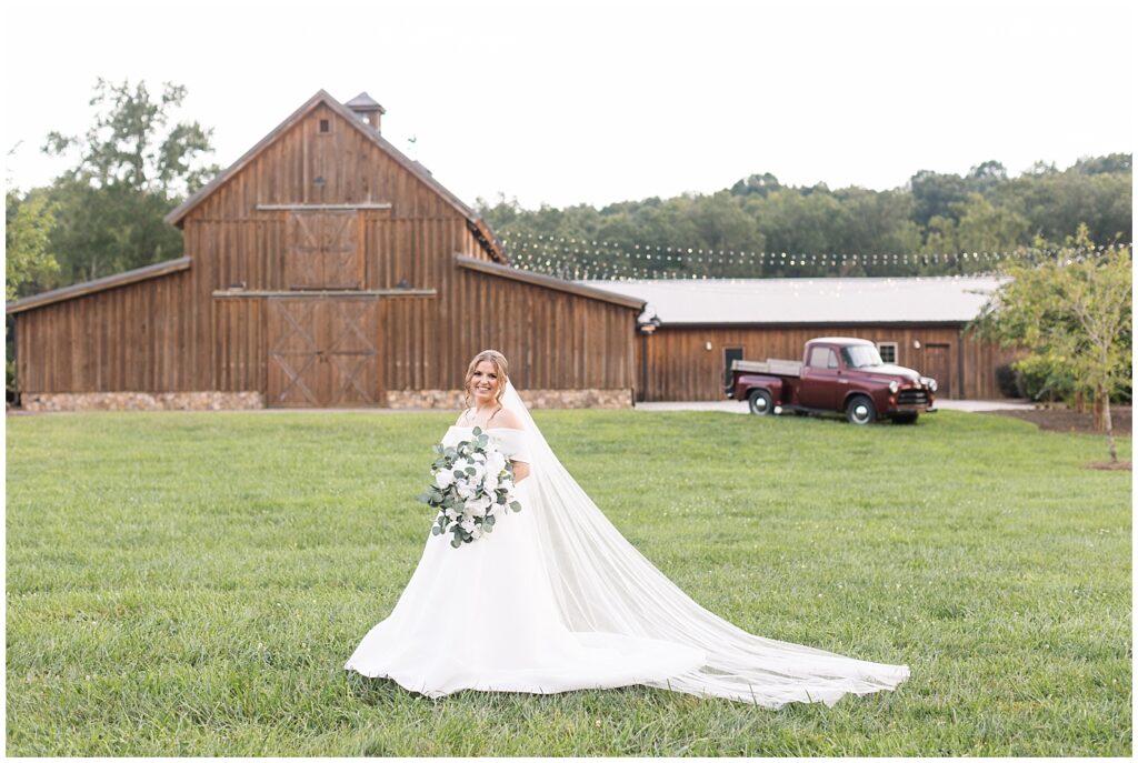Bride holding white bouquet near farm and antique truck | Bridal Portraits at The Farmstead | Rustic Bridal Portraits | Bridal Portrait Photographer