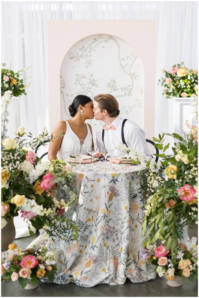 Bride and Groom Sitting at Table with Colorful Flowers