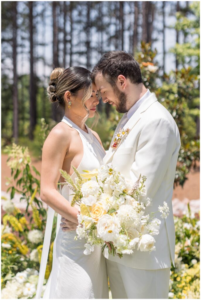 Bride Groom Photos featuring a Mindy Lam Pin on a white groom suit at The Upchurch Wedding Venue in Cary | Raleigh Wedding Photographer