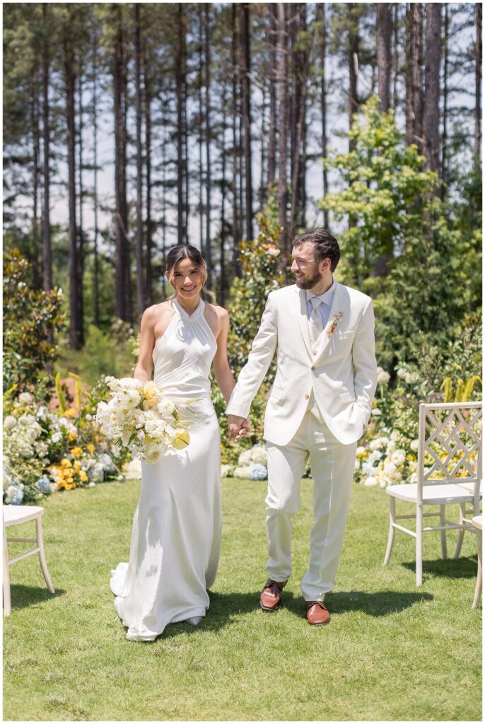 Bride Groom Photos walking down the aisle on the lawn in the summer | The Upchurch Wedding Photos in Cary NC