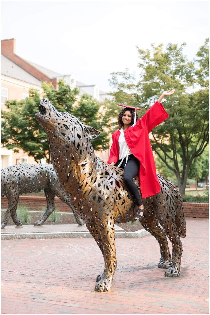 NCSU Senior Photos | NC State grad photo on Wolf Statue | Grad Photographer | Cap and Gown Portraits