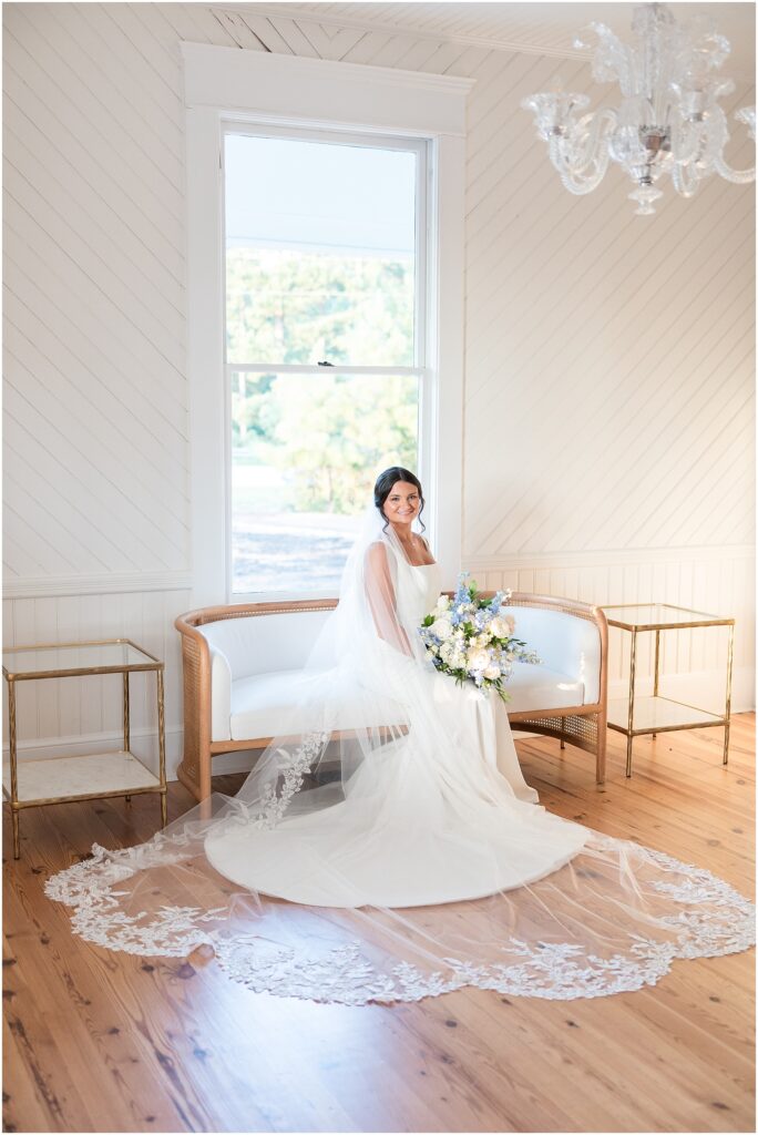 Bridal Portrait sitting on a white couch with a Blue and White Bridal Bouquet | Bridals at The Upchurch | Raleigh Wedding Photographer