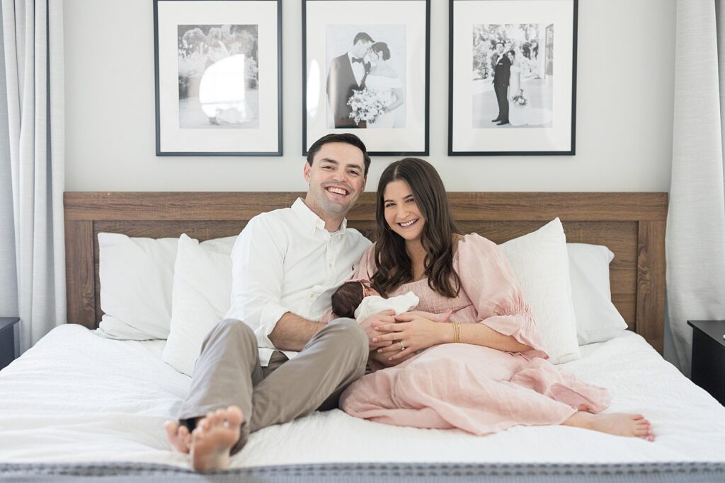 parents holding baby in bed | parents cuddling newborn baby | newborn photography Raleigh NC | baby girl newborn session | lifestyle family photography