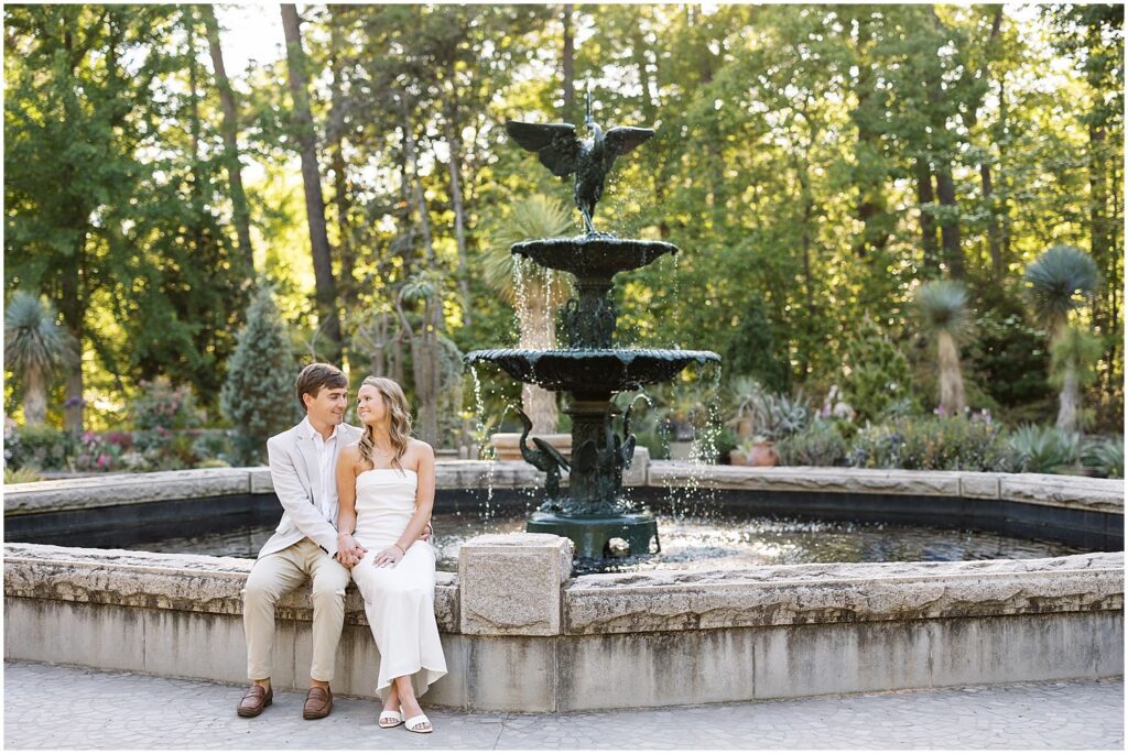 Engagement photo sitting on the fountain edge at Duke Gardens in the spring | Sarah Hinckley Photography