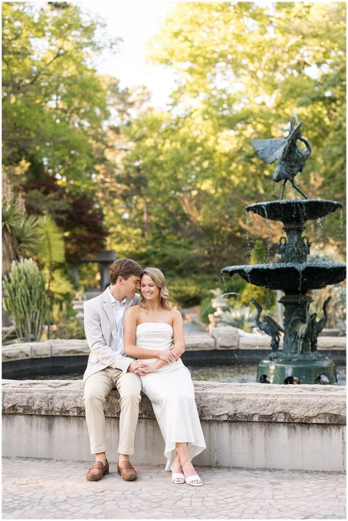 Sitting together by a fountain, romantic spring engagement photos at Duke Gardens | Sarah Hinckley Photography
